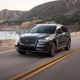 A dark grey Lincoln Corsair driving down a scenic seaside road.
